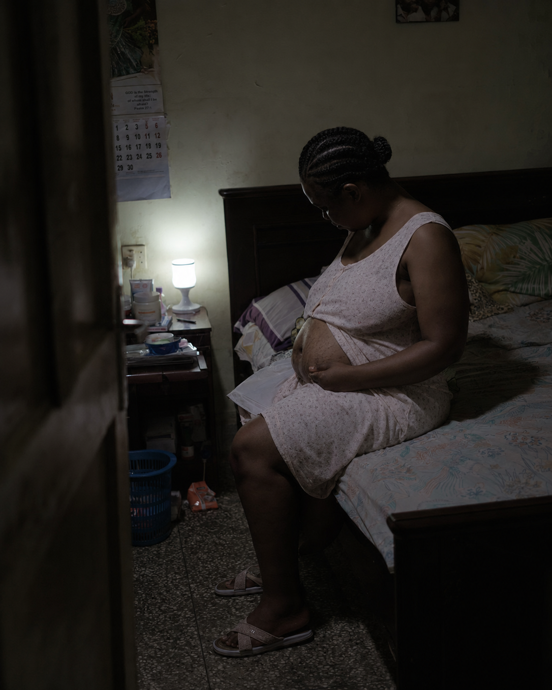 Woman alone at the edge of the bed, quiet evening moment